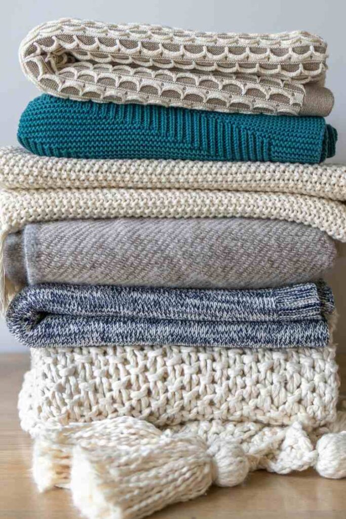 A neat file of folded woolen scarves