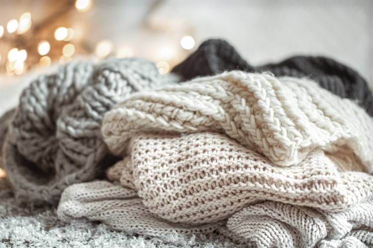 Three cozy and soft woolen scarves in a pile.
