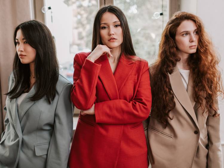 Three women mean business in baggy blazers.